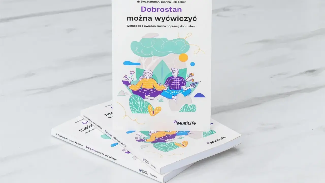 Książka "Dobrostan można wyćwiczyć" z ilustracją pary medytującej. Pomaga żyć i szczęśliwym być.