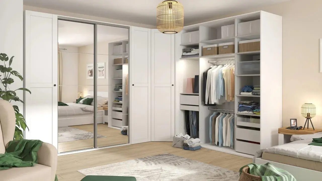Zorganizowana garderoba w stylu Marie Kondo: białe fronty, lustrzane drzwi, półki z pudełkami i wieszaki z ubraniami.