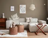 Przytulny salon w stylu feng shui z beżową sofą, drewnianymi stolikami i dekoracjami.