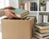 Ręce wkładają książkę do kartonu. Rozważ, co zrobić z niepotrzebnymi książkami, zanim zapełnią półki.