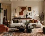Przytulny salon w stylu eklektycznym. Miękka kanapa, aksamitny fotel i bogaty dywan tworzą ciepłą atmosferę.