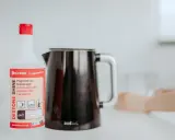 Butelka preparatu do odkamieniania obok czajnika Tefal. Szybki sposób, jak wyczyścić czajnik z kamienia.