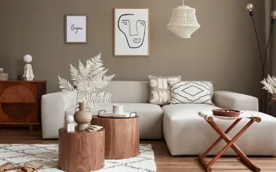 Przytulny salon w stylu feng shui z beżową sofą, drewnianymi stolikami i dekoracjami.