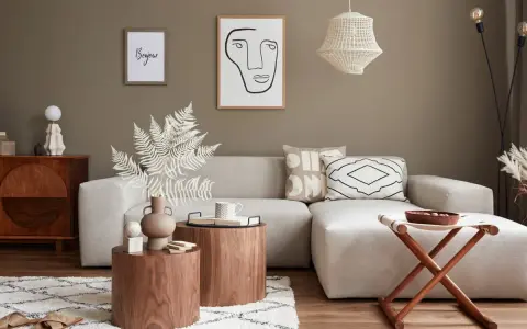 Przytulny salon w stylu feng shui z beżową sofą, drewnianymi stolikami i dekoracjami.