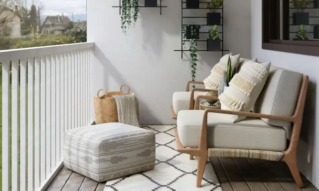Wąski balkon w bloku inspiracje: przytulne fotele, pufy, kosze i rośliny tworzą oazę spokoju.
