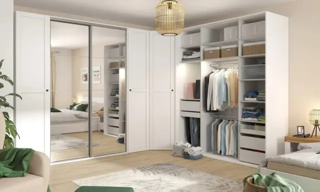 Zorganizowana garderoba w stylu Marie Kondo: białe fronty, lustrzane drzwi, półki z pudełkami i wieszaki z ubraniami.