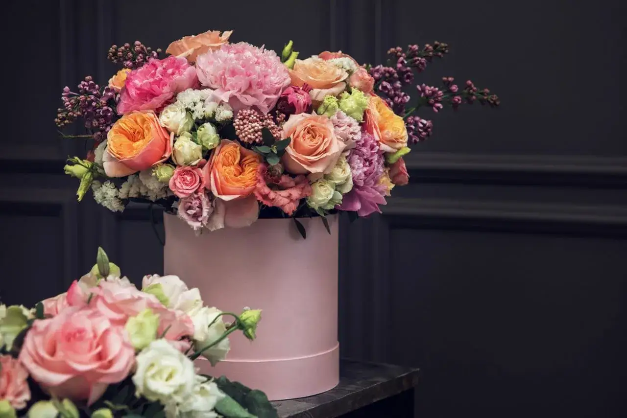 Piękny flower box jak zrobić? Bukiet róż, piwonii i innych kwiatów w różowym pudełku.