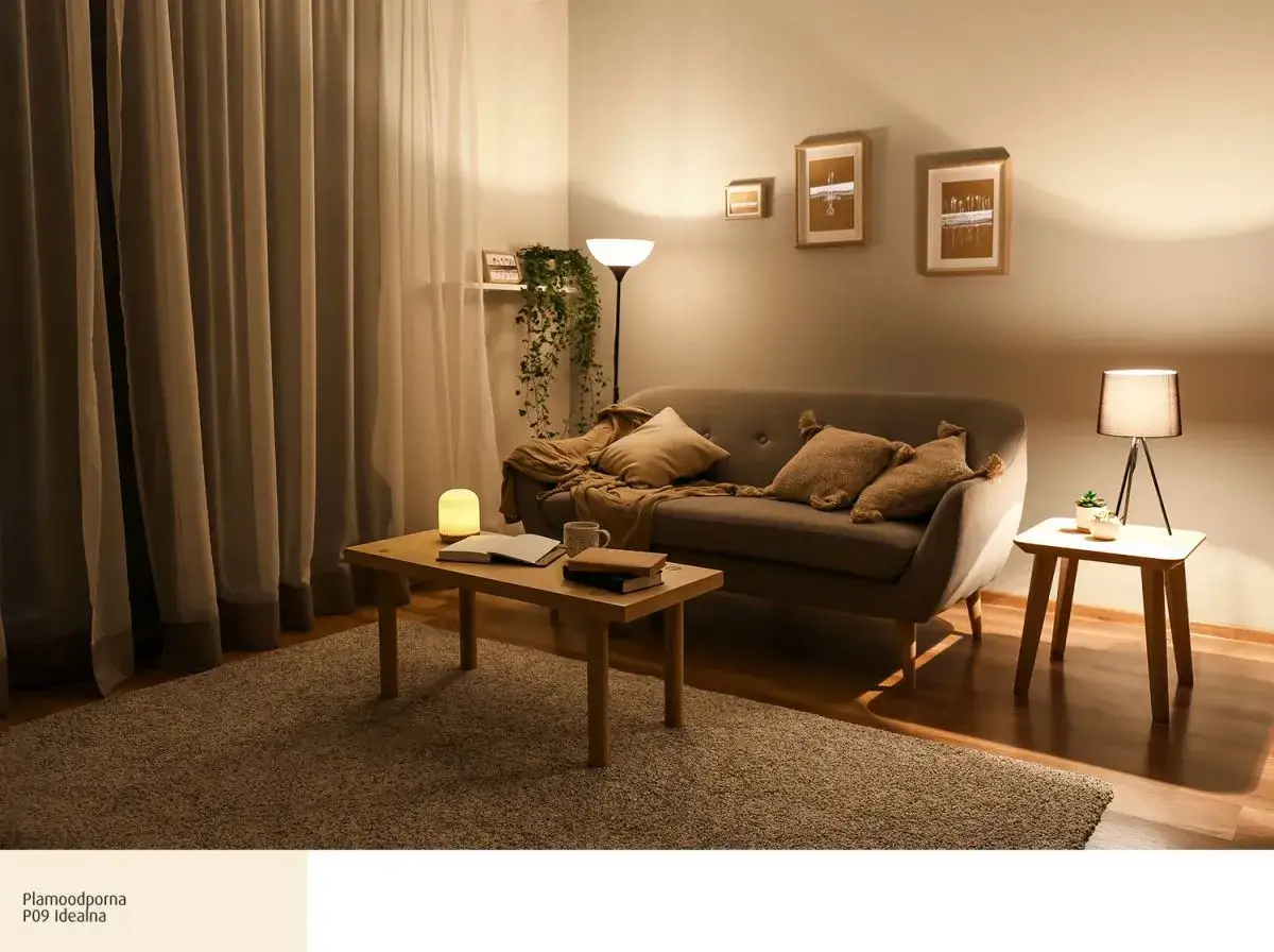 Przytulny salon z sofą, stolikiem i dywanem. Ciepłe kolory ścian tworzą relaksującą atmosferę.