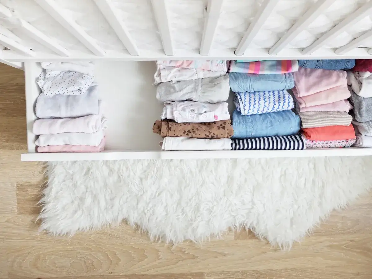 Ubranka dziecięce złożone metodą Marie Kondo, idealnie poukładane w szufladzie.